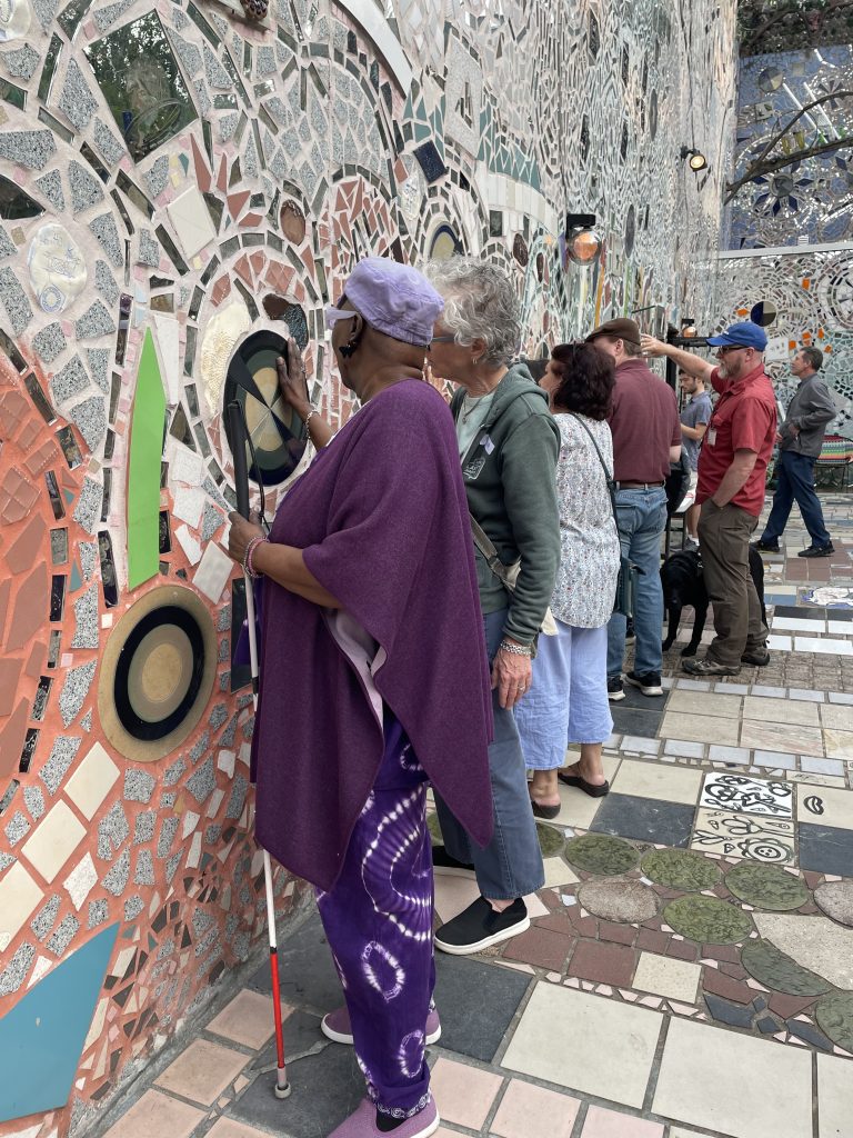 During a Philly Touch Tours expedition, Simon Bonenfant explores one of the Magic Gardens mosaic walls while father Ron looks on.